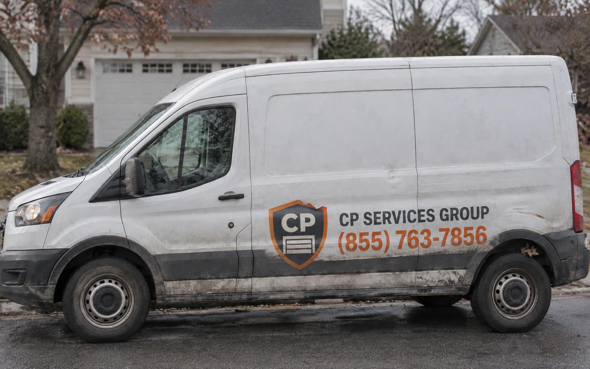CP Services Group service van parked at a home, phone number on the side